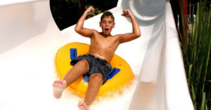 Boy riding tube down waterslide