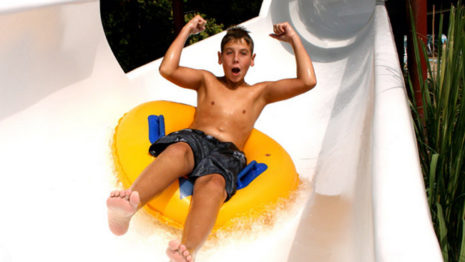 Boy riding tube down waterslide